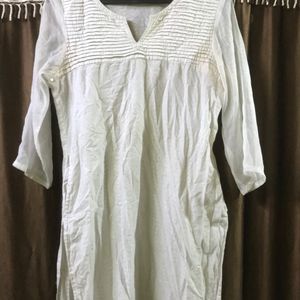 White kurti with net sleeves and a pair of jhumka