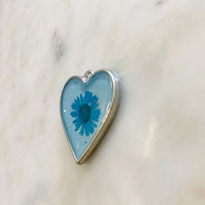 Heart shaped pendant with real flower in it