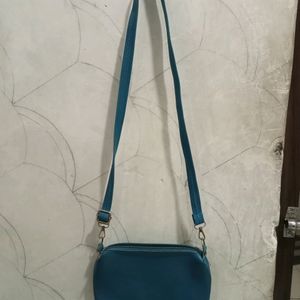 A Blue Colour Slingbag. It Has 1 Section Only.