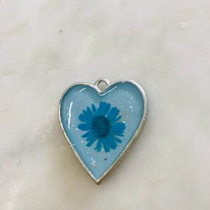 Heart shaped pendant with real flower in it