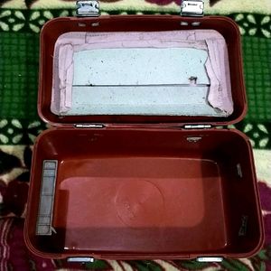 IT IS RED COLOR MAKEUP PLASTIC VANITY BOX......