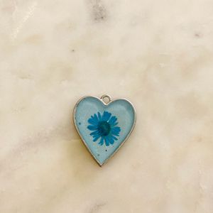 Heart shaped pendant with real flower in it