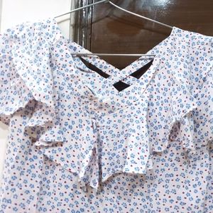 A pretty light pink and blue flower print top. It has a criss cross design on back. Size is medium but can fit a large too.