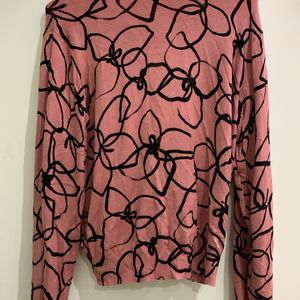 Pink sweater with black geometric pattern