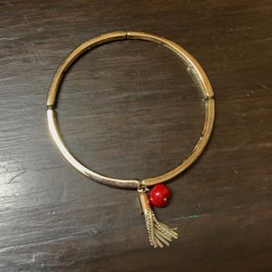 Elegant Metallic Bracelet With a Red Bead