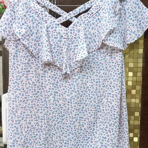 A pretty light pink and blue flower print top. It has a criss cross design on back. Size is medium but can fit a large too.