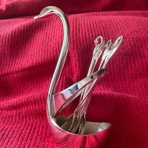 Product: Swan desert spoon stand. Material: Nickle