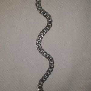 It is a silver Hand Chain Bracelet