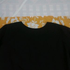 Black Crape Kurtha With  Yellow Border At Front.have White Flowers In It. Round Neck With 3/4 th Sleevs