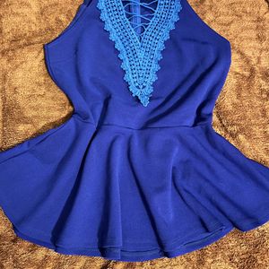 A Peplum Top With Lace Detail On Neck