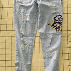 Denim jeans with flower pattern stitched on it