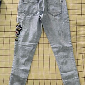 Denim jeans with flower pattern stitched on it