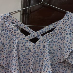 A pretty light pink and blue flower print top. It has a criss cross design on back. Size is medium but can fit a large too.