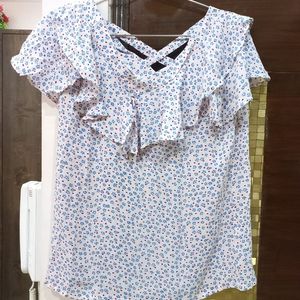 A pretty light pink and blue flower print top. It has a criss cross design on back. Size is medium but can fit a large too.