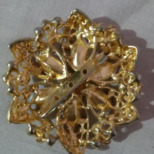 A Broach Of Metal With Diamonds