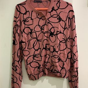 Pink sweater with black geometric pattern