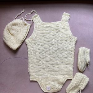 A Crochet Set Of Romper, Bonnet And Booties