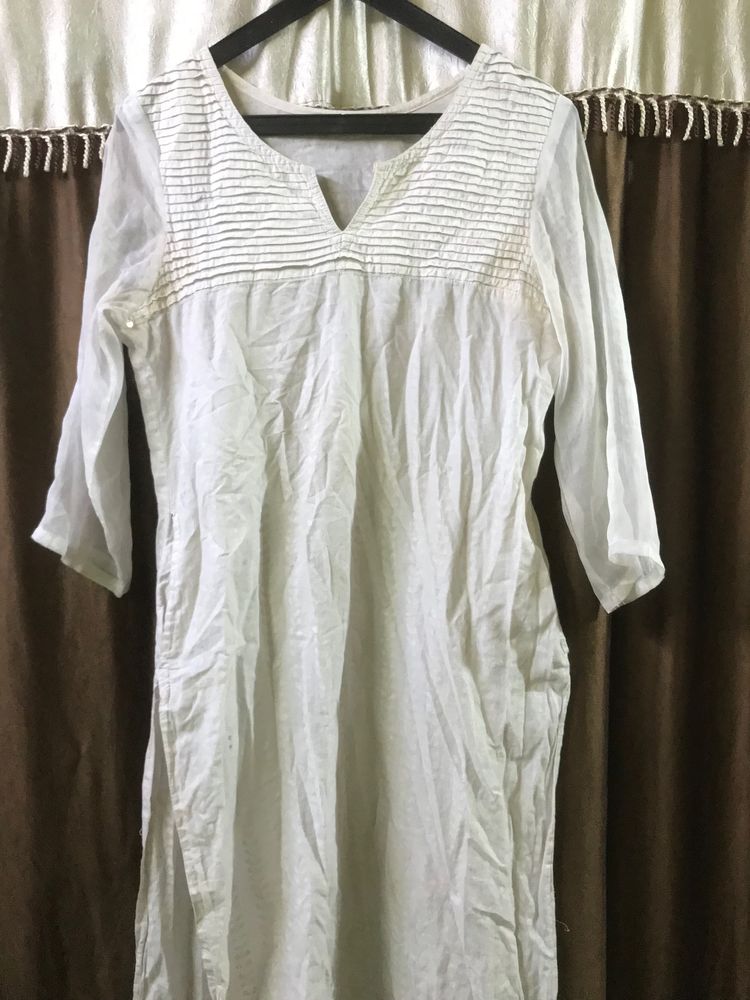 White kurti with net sleeves and a pair of jhumka