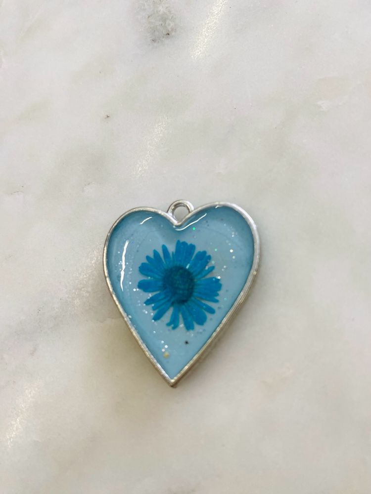 Heart shaped pendant with real flower in it