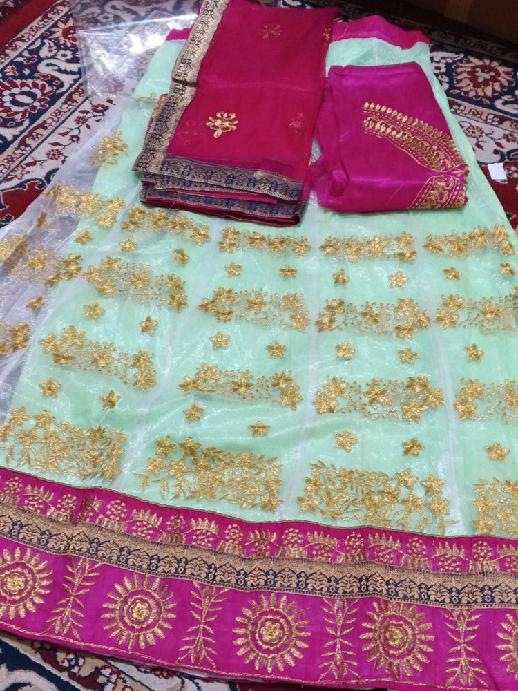 Net Lahenga With Net Dupatta And Raw Silk Blouse Piece