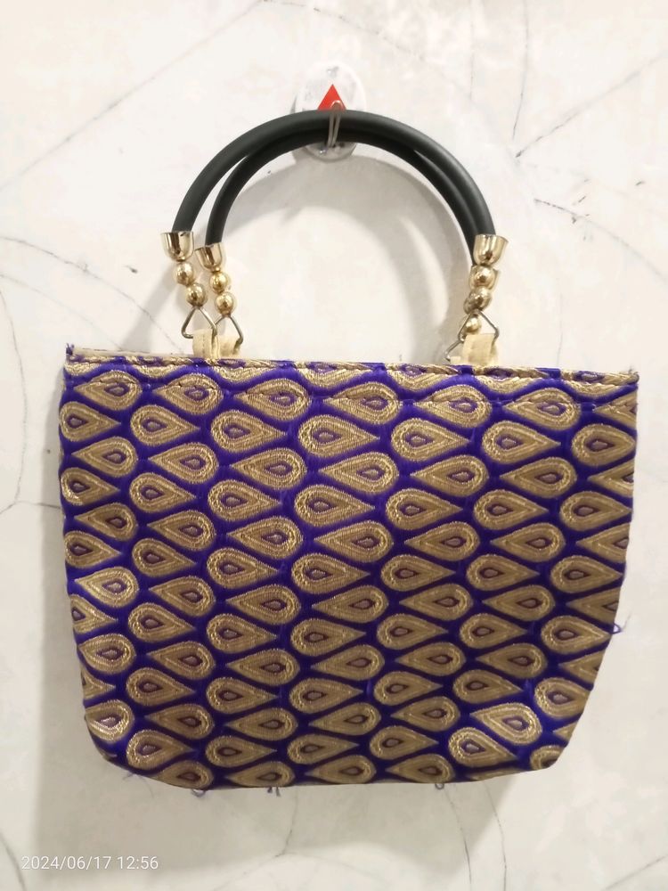 A Purple Colour Handbag. U Can Carry It With Saree
