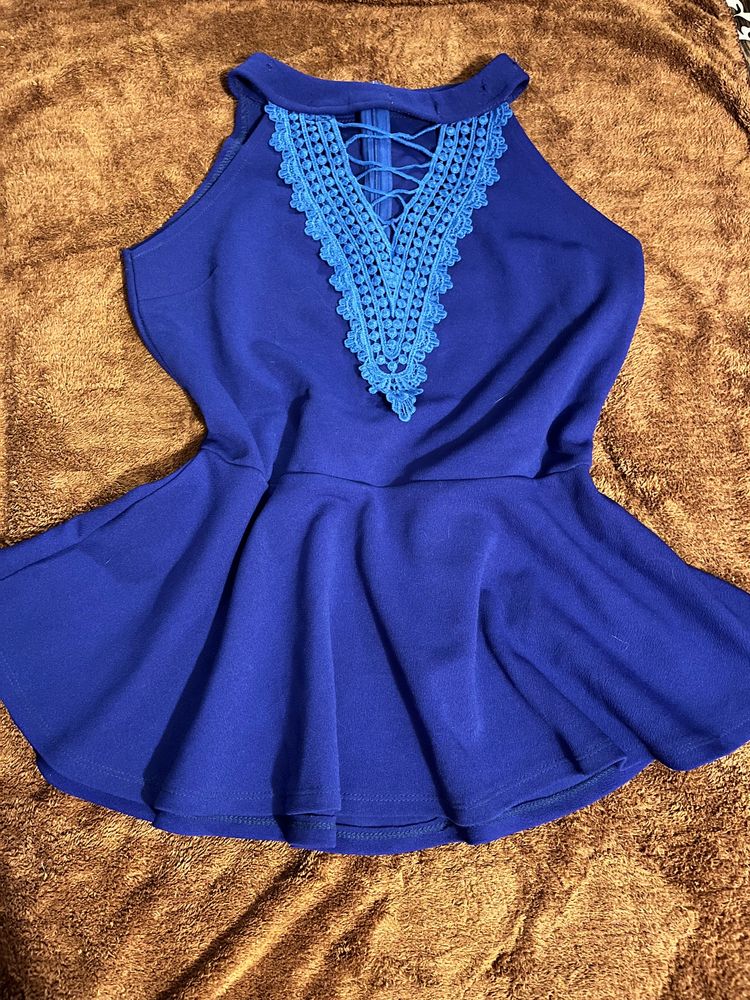 A Peplum Top With Lace Detail On Neck