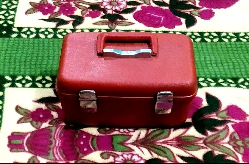 IT IS RED COLOR MAKEUP PLASTIC VANITY BOX......